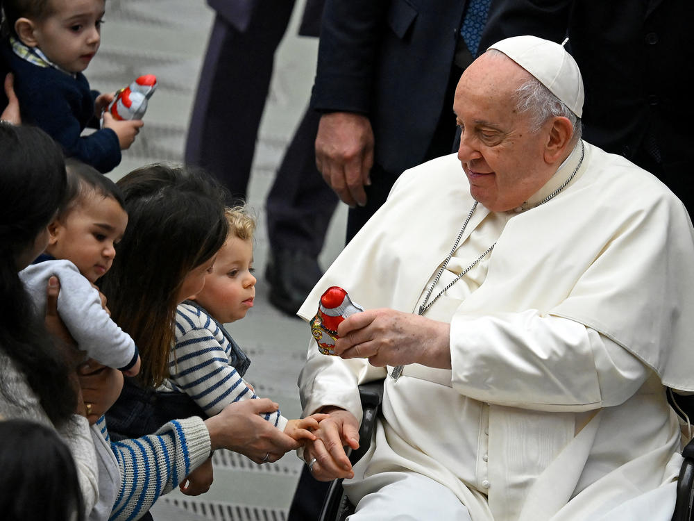 Pope Francis distributes sweets to children during the weekly general audience in Paul VI hall at the Vatican on Jan. 3.
