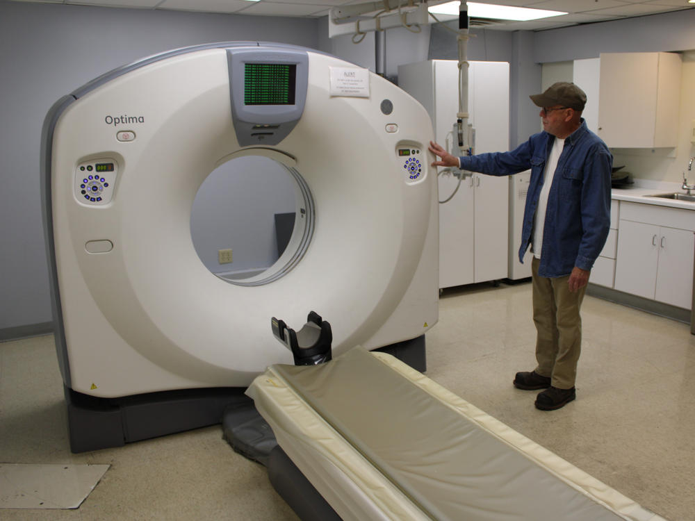 Bruce Mackie, the Keokuk hospital's sole remaining staffer, looks at a CT scanner waiting to be used again. He hopes to see the hospital reopen in 2024.