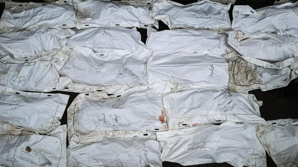 Bodies of those killed in an Israeli strike are set out during a mass funeral at al-Aqsa hospital in Gaza on Dec. 25.