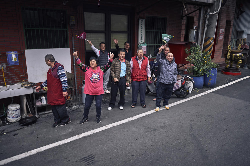 Residents watch as Su drives past, some cheering her on.