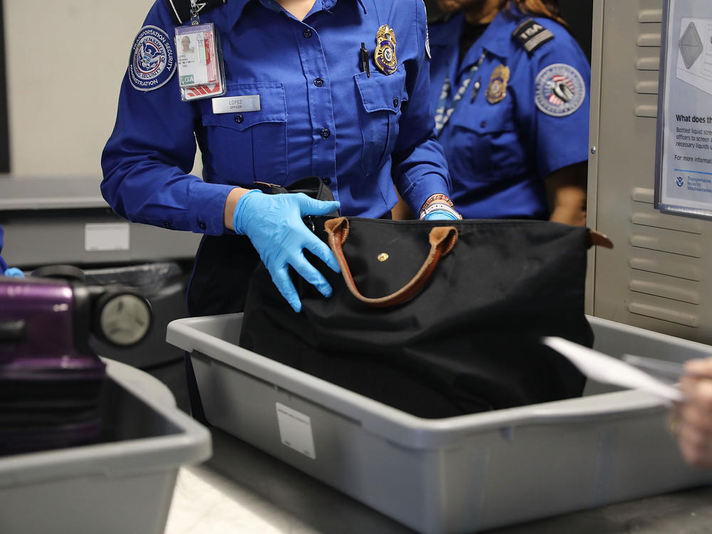 A Transportation Security Administration worker screens luggage at New York's LaGuardia Airport on Sept. 26, 2017. The TSA says it found a record number of firearms at airport security checkpoints last year.