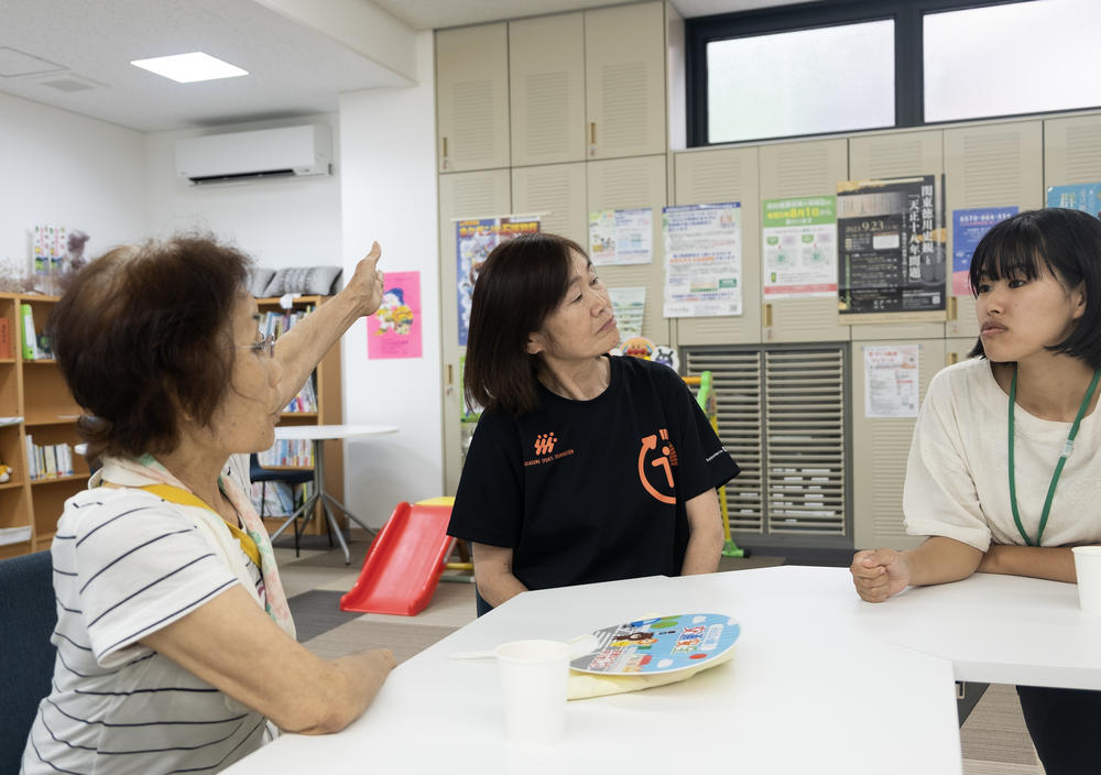 Nanmoku village housing coordinator Satomi Oigawa (right) meets with a village resident (left) and staffer (center) at a village community center for senior citizens. The center offers, among other things, exercise equipment, computerized cognition tests and live TV broadcasts of village assembly meetings.