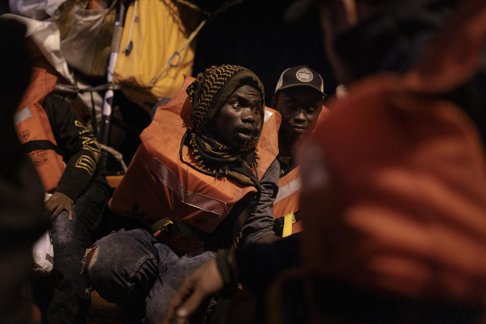 Migrants from different countries sit on a raft headed to the MV Geo Barents rescue ship.