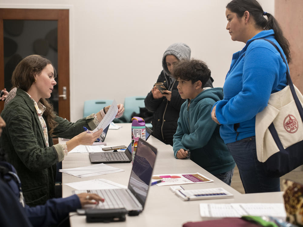 Amelia Hulbert (left) from Boulder County Public Health talks to Maribel Martinez and her son, Ivan.