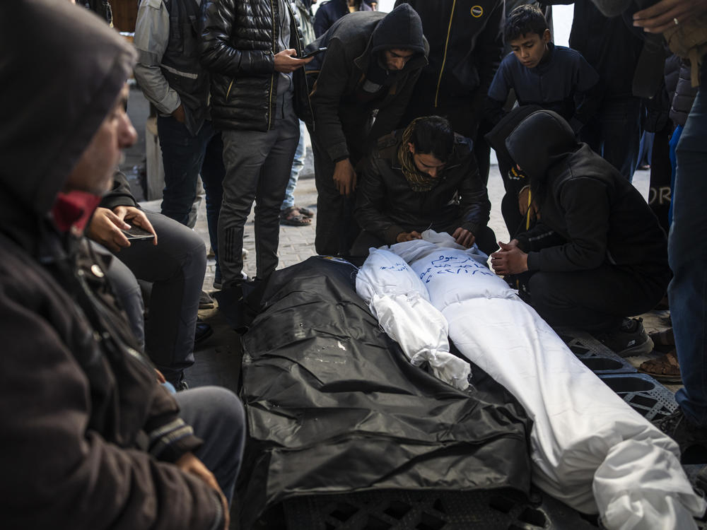 Palestinians mourn relatives killed in the Israeli bombardment of the Gaza Strip in Rafah, Saturday, Jan. 13, 2024.