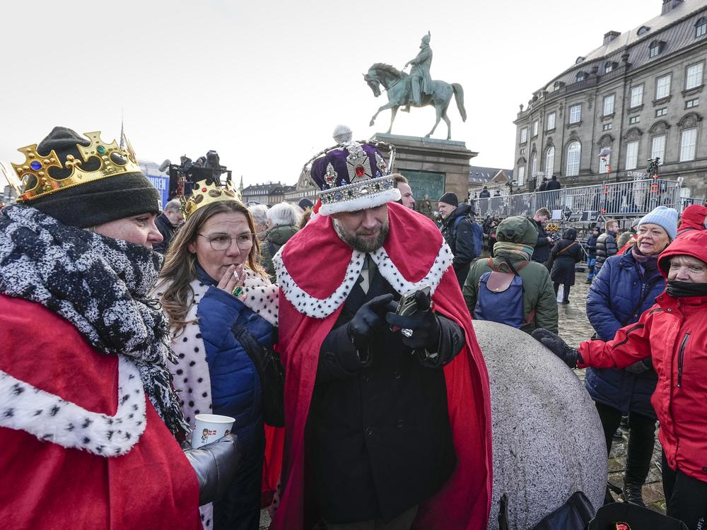 People dressed as kings and queens wait at Christiansborg castle in Copenhagen, Denmark, on Sunday, Jan. 14, 2024, as Denmark's Crown Prince Frederik takes over the crown from his mother, Queen Margrethe II.
