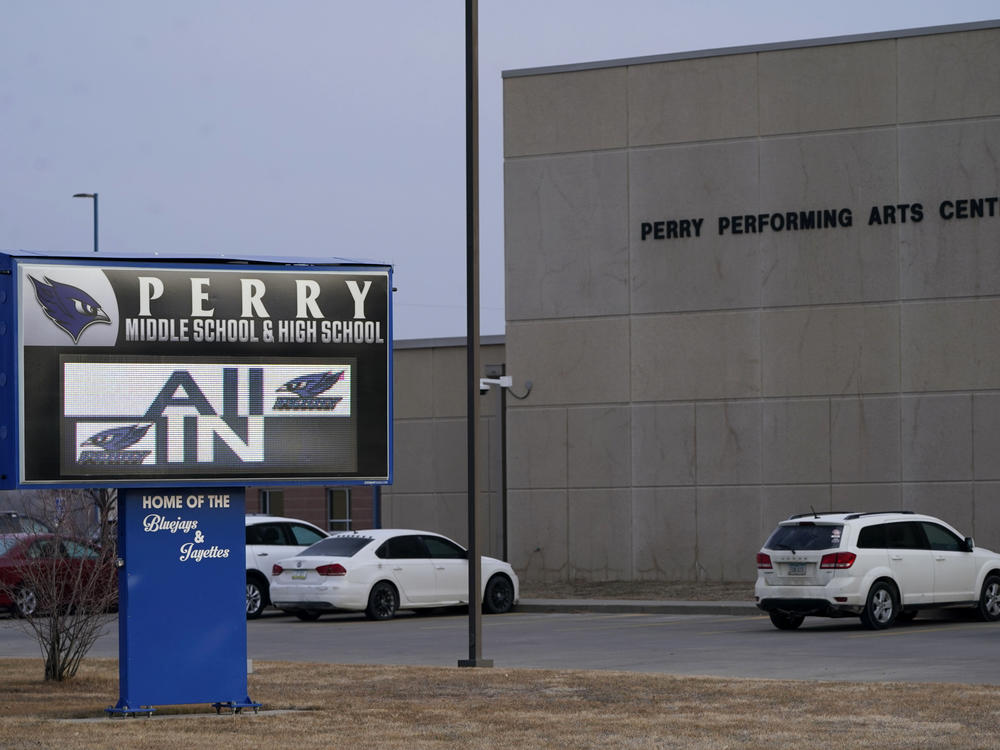 Vehicles are seen in a parking lot outside of Perry High School in Iowa the day after a shooting on Jan. 4, 2024. Dan Marburger, the school's principal who put himself in harm's way to protect students during the shooting, died Sunday, Jan. 14, 2024, a funeral home confirmed after Marburger's after the family announced it on a GoFundMe page.