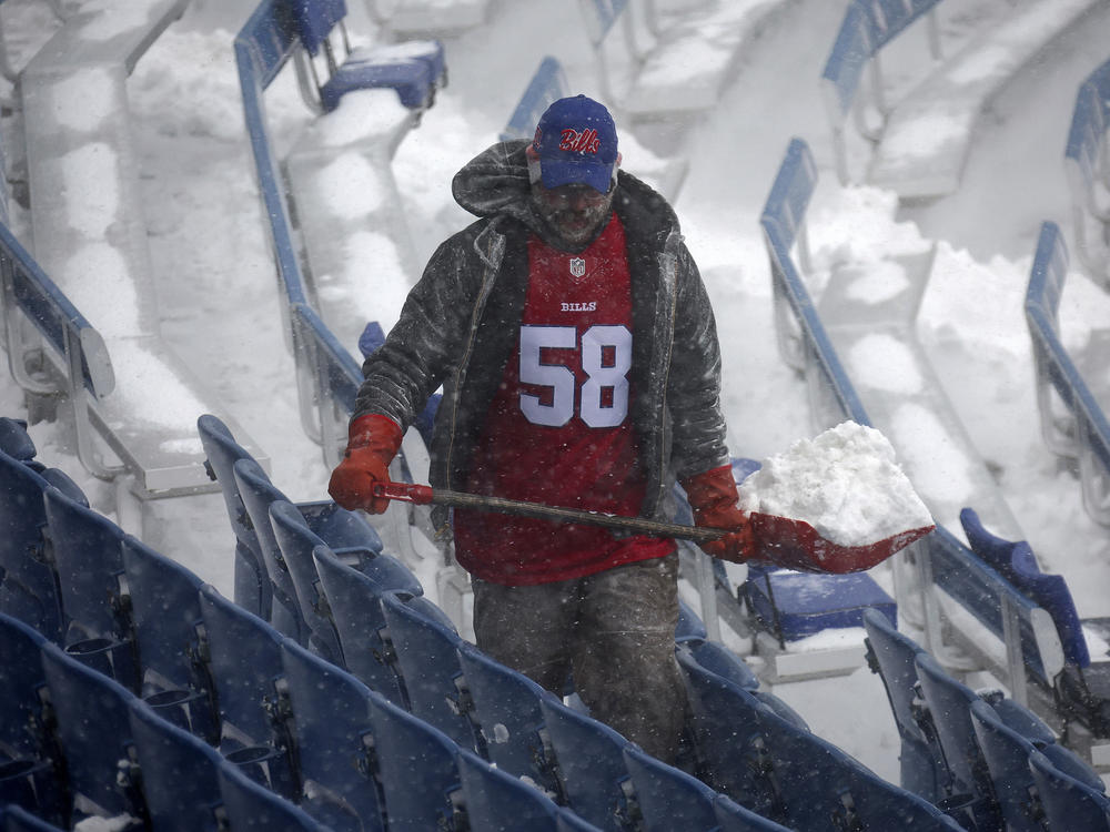 A worker helps remove snow from Highmark Stadium in Orchard Park, N.Y., Sunday Jan. 14, 2024. A potentially dangerous snowstorm that hit the Buffalo region on Saturday led the NFL to push back the Bills wild-card playoff game against the Pittsburgh Steelers from Sunday to Monday.