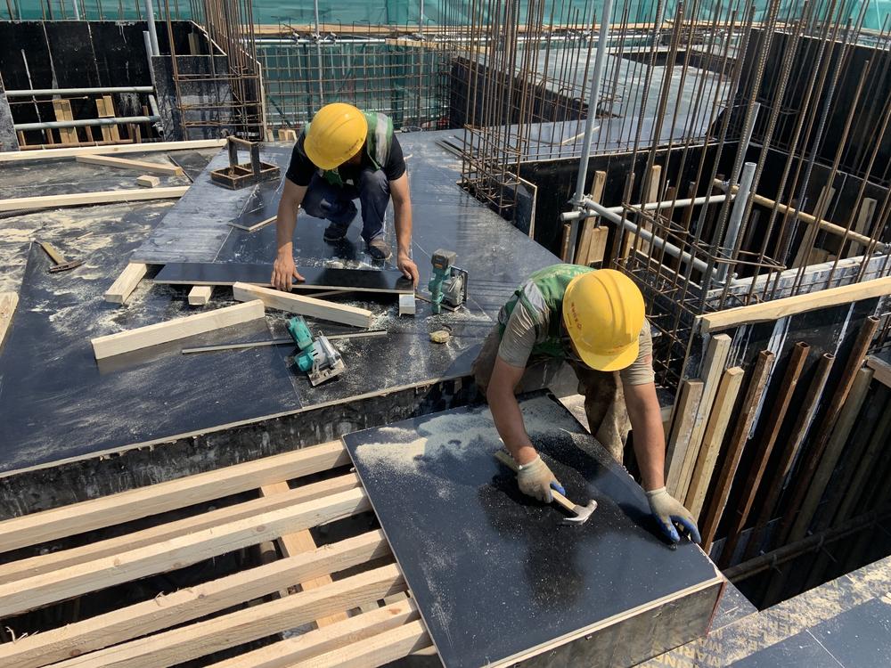 Construction workers build a housing compound in Beijing.