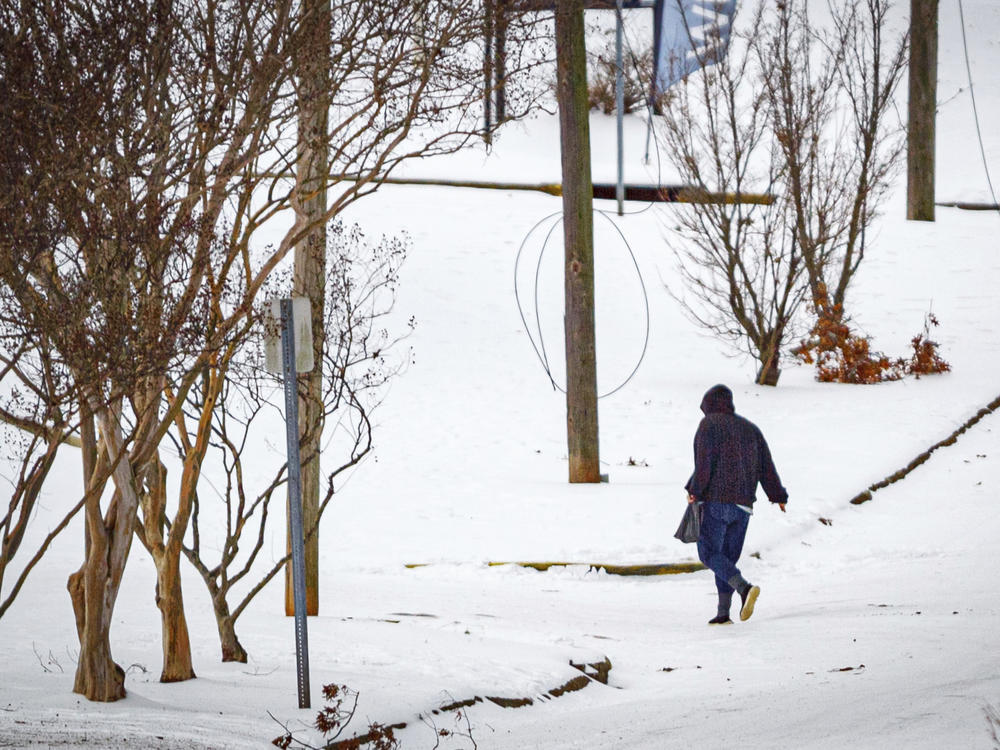 A person walks in icy conditions in downtown Florence, Ala., on Thursday, Jan. 18, 2024.