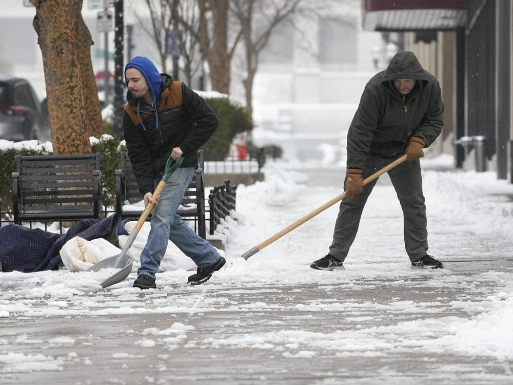 Jesse Asher, left, and Eric Magas shovel snow on Thursday, Jan. 18, 2024, in Nashville, Tenn. A snowstorm blanketed the area with up to 9 inches of snow and frigid temperatures.