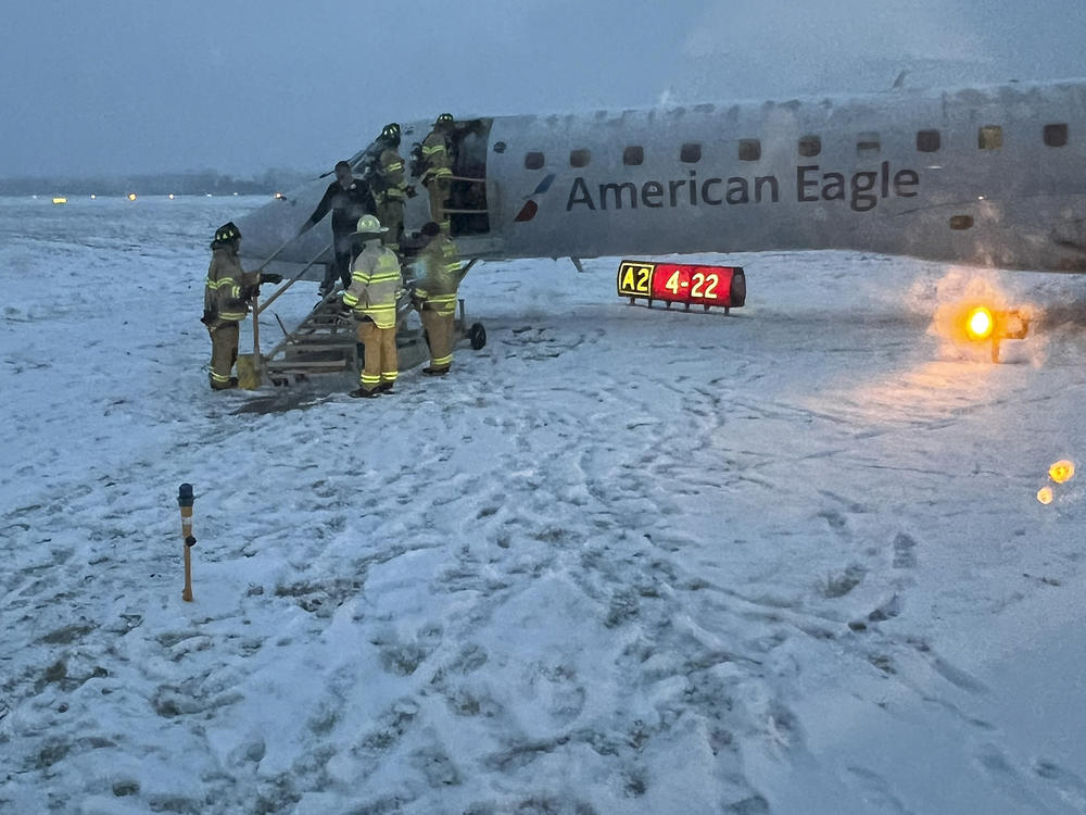 Greater Rochester International Airport firefighters assist passengers off an American Airlines plane that slid off a snowy taxiway after a flight from Philadelphia on Thursday, Jan. 18, 2024, in Rochester, N.Y.