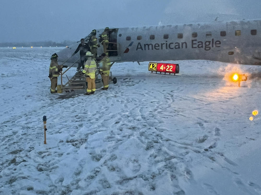 Greater Rochester International Airport firefighters assist passengers off an American Airlines plane that slid off a snowy taxiway after a flight from Philadelphia on Thursday, Jan. 18, 2024, in Rochester, N.Y.