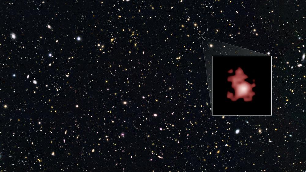 This image shows a 'close-up' of the galaxy GN-z11 as imaged by the Hubble Space Telescope, superimposed on top of another image marking the galaxy's location in the sky.