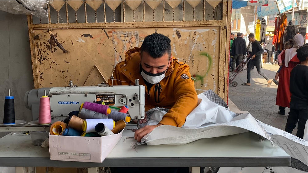 Bags that were used to transfer aid into Gaza are now being repurposed into tent walls.