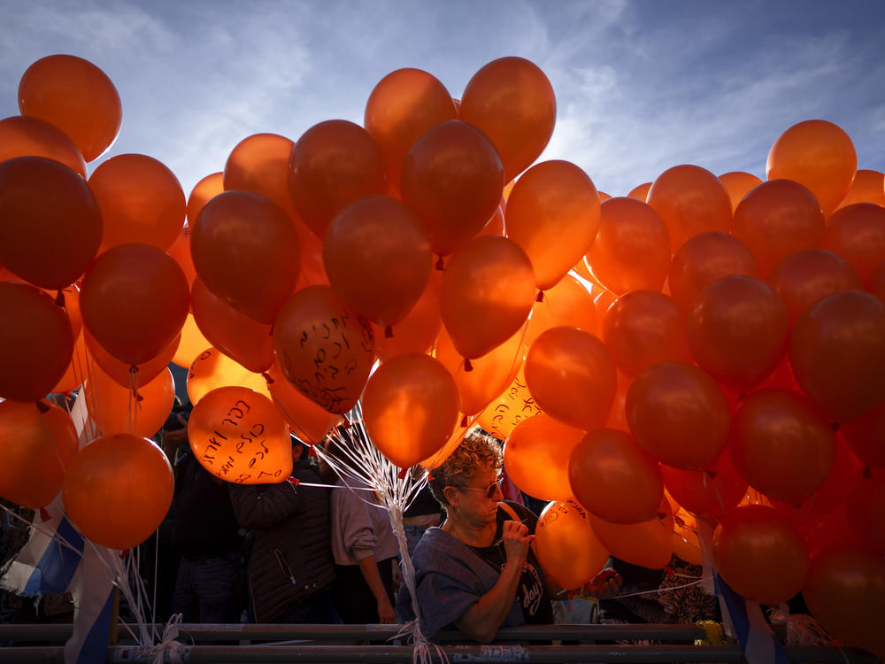 Demonstrators hold orange balloons at a rally in solidarity with Kfir Bibas, an Israeli boy who spent his first birthday Thursday in Hamas captivity in the Gaza Strip, in Tel Aviv, Israel, Thursday, Jan. 18, 2024.