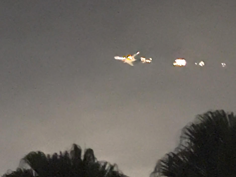 This image taken from video provided by Melanie Adaros shows what she said were sparks shooting from a cargo plane before it made an emergency landing at Miami International Airport on Thursday.