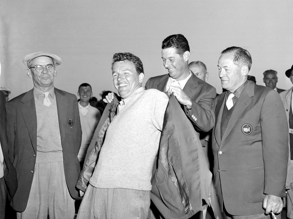 Jack Burke Jr. is helped by Cary Middlecoff as he puts on the traditional coat after winning the 20th Masters Golf Tournament at the Augusta National Golf Course in Augusta, Ga., on April 8, 1956. Burke, the oldest living Masters champion, died Friday in Houston. He was 100.