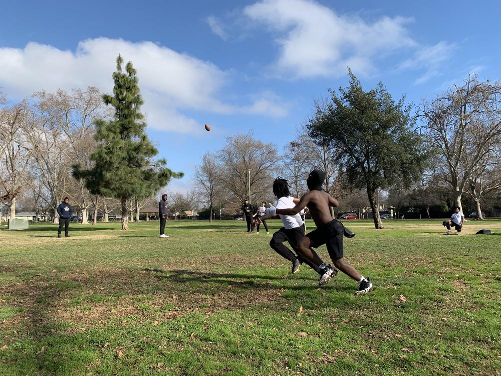 Eleven-year-old Monte Johnson and 9-year-old Waylon Parker run for the ball at a 7-on-7 practice at Tahoe Park in Sacramento, California on Jan. 14, 2023