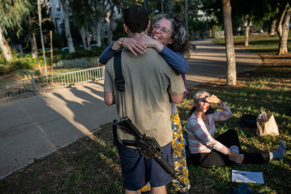 Yifah Sahar embraces her son, an Israeli soldier who is not serving in Gaza, after she attended a meeting with a newly formed group of mothers calling to end the Gaza war. She says there is no contradiction between supporting her son and opposing the ground invasion of Gaza.