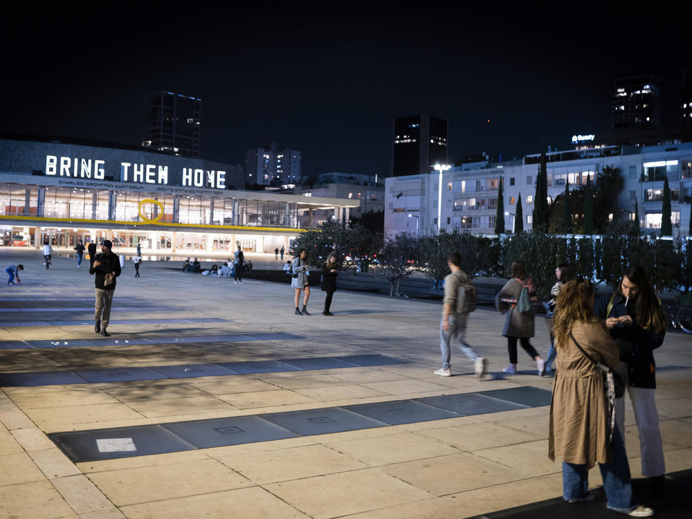 The National Theater of Tel Aviv is illuminated with signs that read 