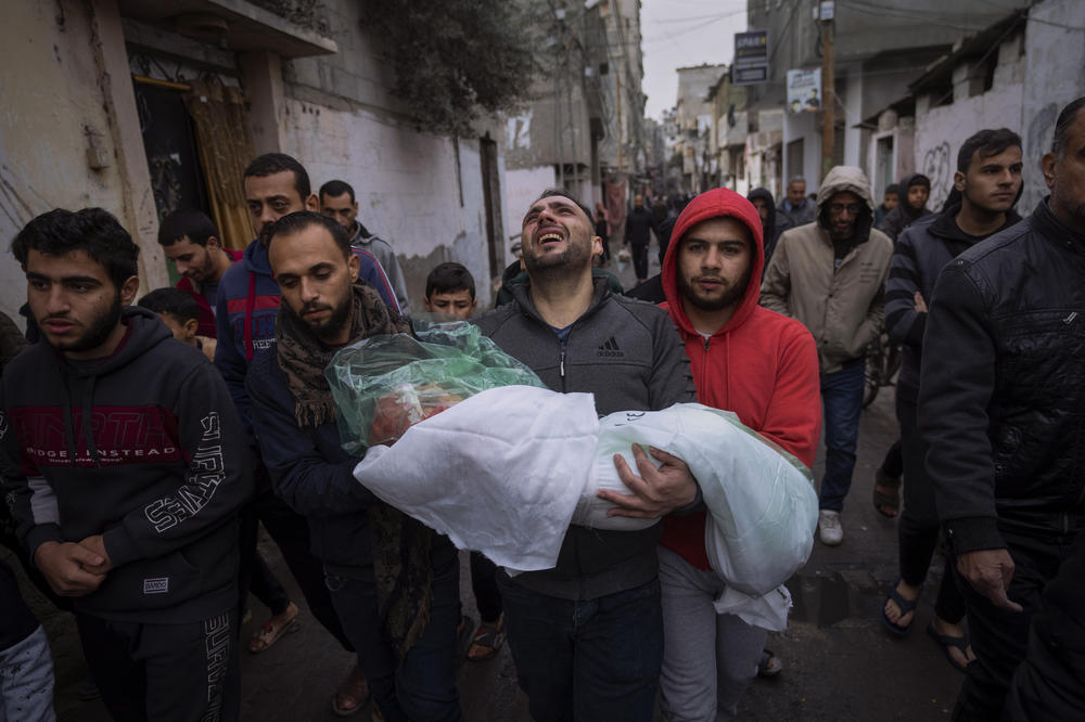 Mohammad Shouman carries the body of his daughter, Masa, who was killed in an Israeli bombardment of the Gaza Strip, during her funeral in Rafah on Jan. 17.