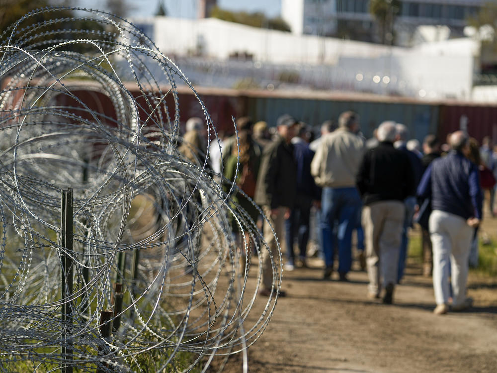 Concertina wire lines the path as members of Congress tour an area near the Texas-Mexico border, Jan. 3, 2024, in Eagle Pass, Texas.