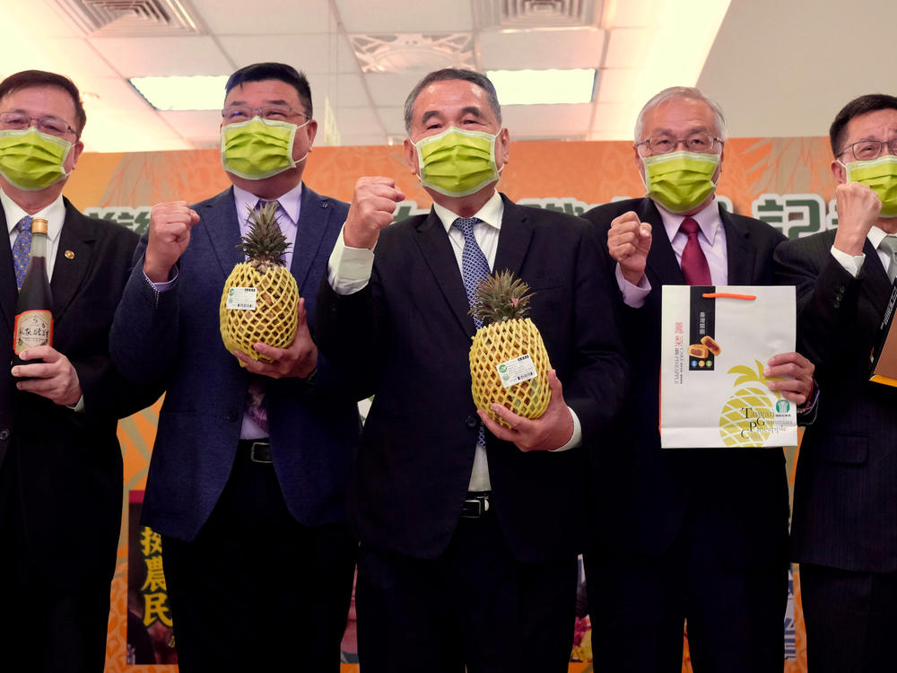 Officials from the Agriculture Bank of Taiwan pose at a press conference to promote domestically grown pineapples and their exports, at the bank's headquarters in Taipei on March 5, 2021.