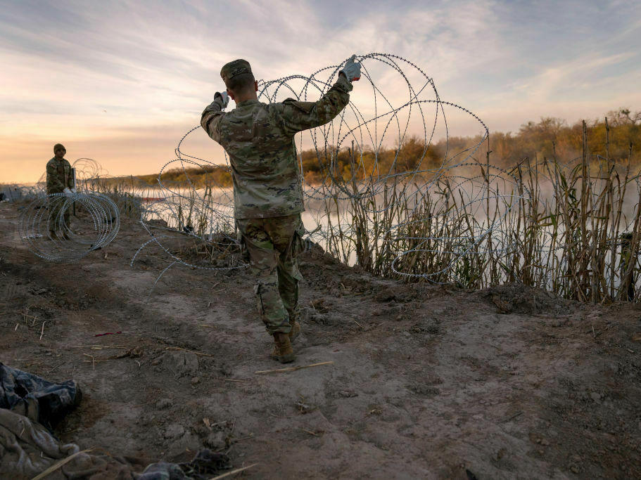Texas National Guard soldiers install additional razor wire lie along the Rio Grande on Jan. 10 in Eagle Pass, Texas.