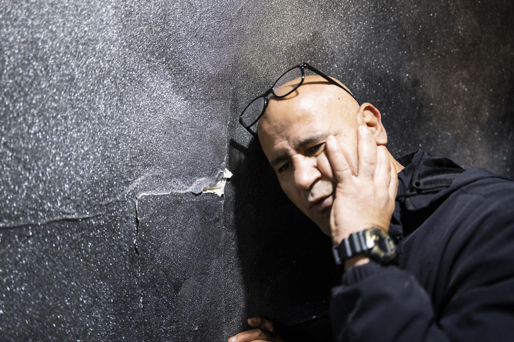 Ashraf Jaradat recreates the moment when he says Israeli soldiers slammed his head into a wall inside his home. Israeli soldiers also bulldozed his road, exposing sewage lines, beat him in front of his children and detained him for three days, he says.