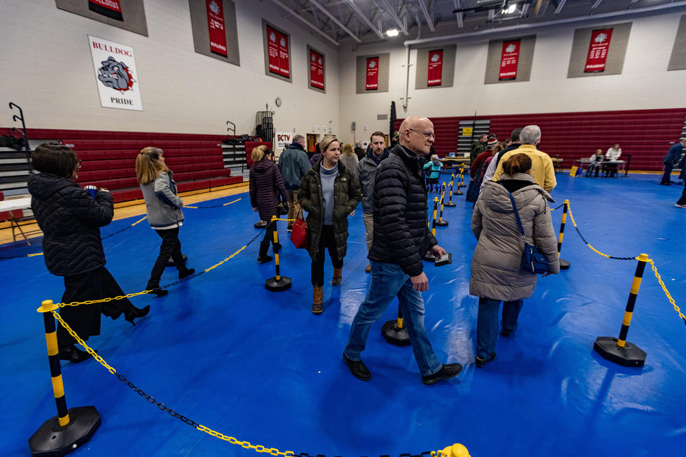 Voters at Bedford High School walk through ropes in line to collect their ballots to vote in Bedford, N.H. on Jan. 23, 2024.