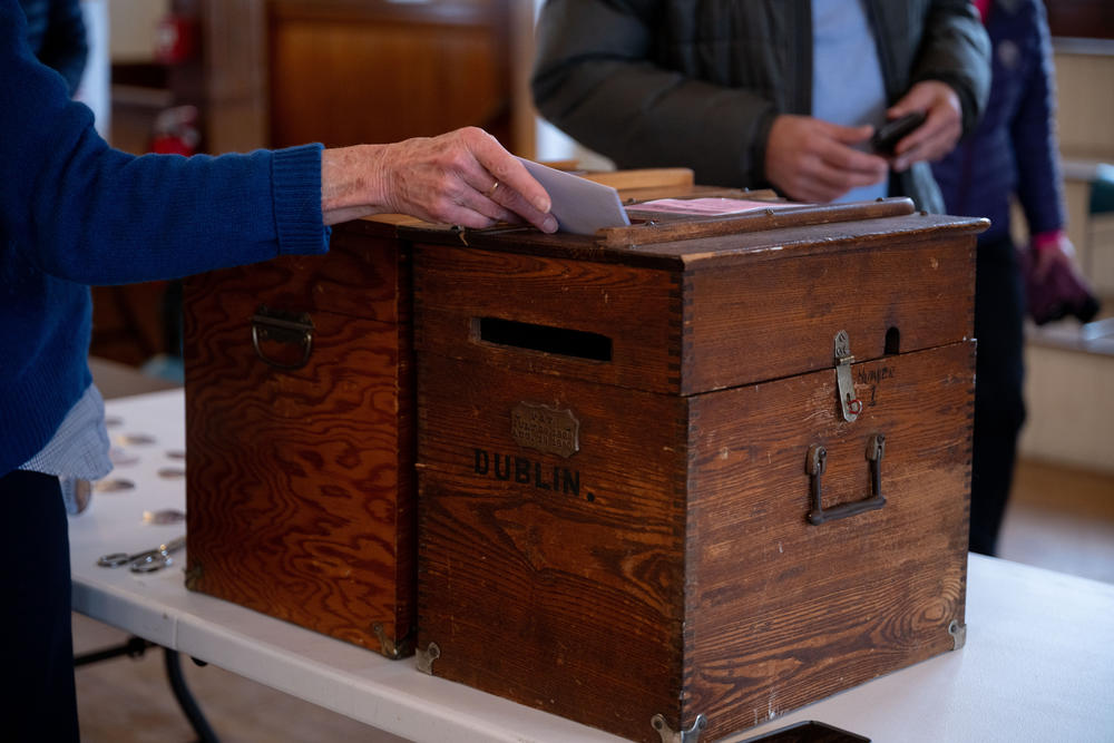 Mary Loftis, 76, an Assistant Moderator at the Dublin Town Hall polling place, helps voters turn in their ballots on Tuesday, Jan. 23, 2023, in Dublin, N.H.