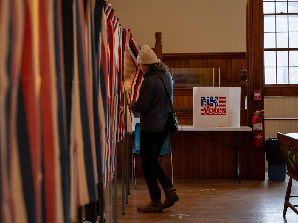Voter Katie Wilson, 58, walks into a voting booth at the Dublin Town Hall polling place, on Tuesday, Jan. 23, 2024, in Dublin, N.H.