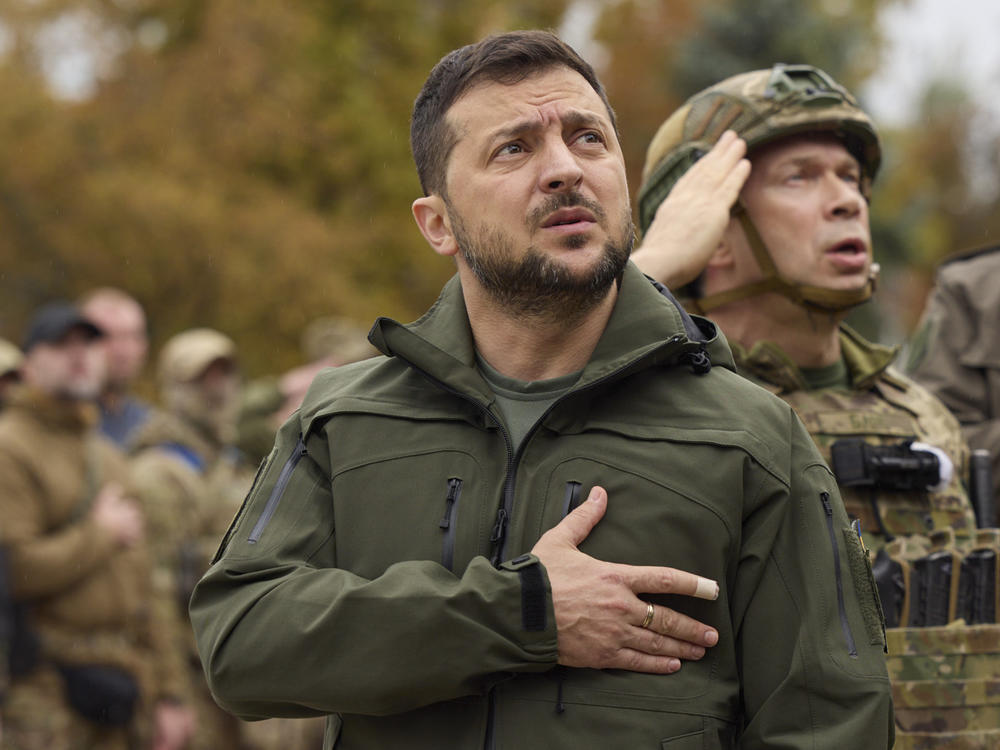 Ukrainian president Volodymyr Zelenskyy sings the national anthem during a visit to the city of Izium, in the Kharkiv, Sept. 14, 2022.