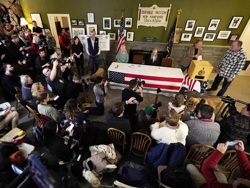 A large crowd of media and spectators watch as town moderator Tom Tillotson inserts Scott Maxwell's ballot shortly after midnight in the presidential primary election, Tuesday, Jan. 23, 2024, in Dixville Notch, N.H.