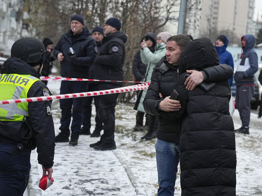 People react at the site of a Russian attack in Kyiv, Ukraine, Tuesday, Jan. 23, 2024.