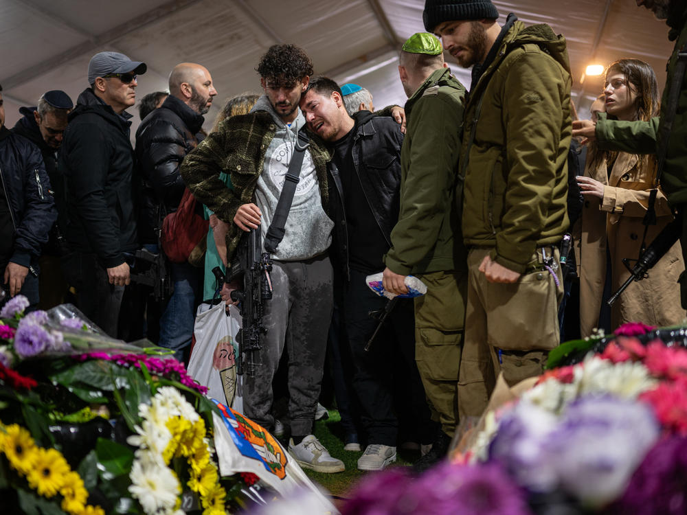 Family and friends of Israeli reservist Hadar Kapeluk, who was killed in combat in Gaza, mourn at his grave during his funeral at the Mount Herzl military cemetery in Jerusalem on Tuesday.