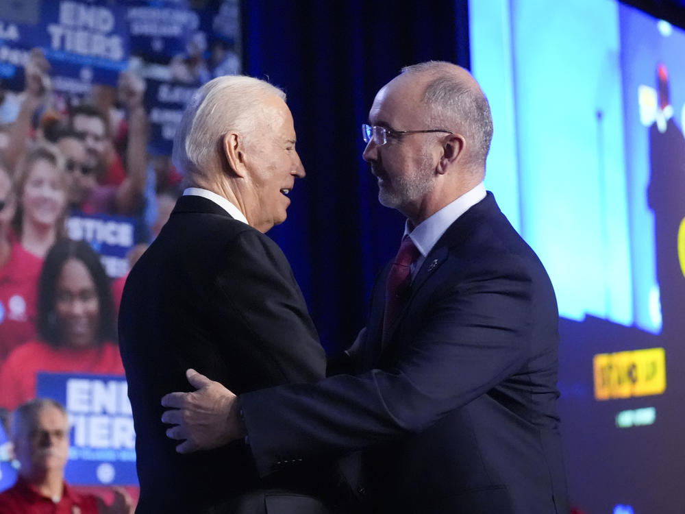 President Biden is greeted by Shawn Fain, President of the United Auto Workers. The union endorsed Biden's reelection bid on Wednesday.