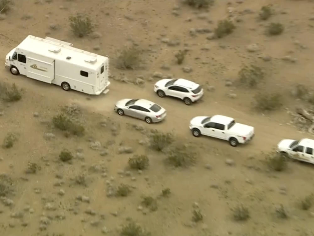 This image from video provided by KTLA shows law enforcement vehicles where several people were found shot to death in El Mirage, Calif., on Wednesday, Jan. 24, 2024. Deputies found the bodies of six people at a remote dirt crossroads in the Mojave Desert in Southern California.