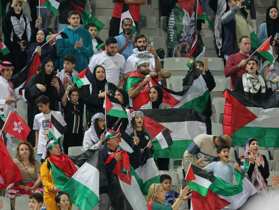 Soccer fans wave Palestinian flags at the AFC Asian Cup Group C soccer match between Hong Kong and the Palestinian soccer team.