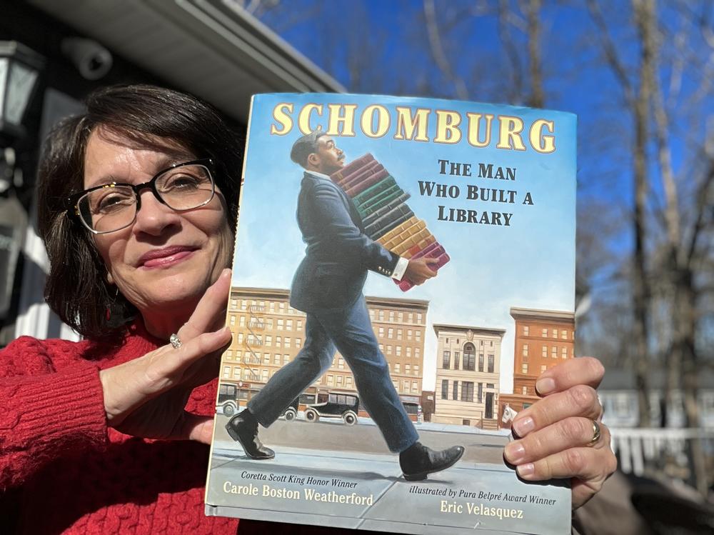 Meg Medina, the 2023 – 2024 National Ambassador of Young People's Literature and a children's author, holds her book choice for Black History Month.