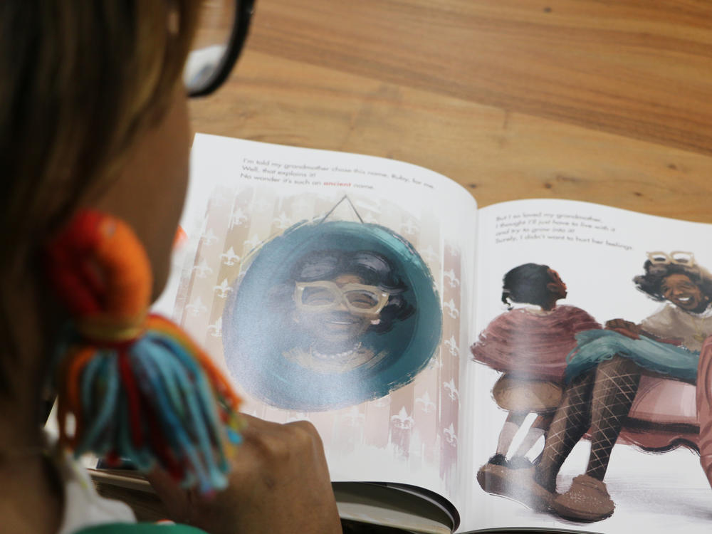 Brittni Robertson Powell, with the New Orleans-based bookstore Baldwin & Co. looks through her choice for Black History Month: <em>I Am Ruby Bridges.</em>