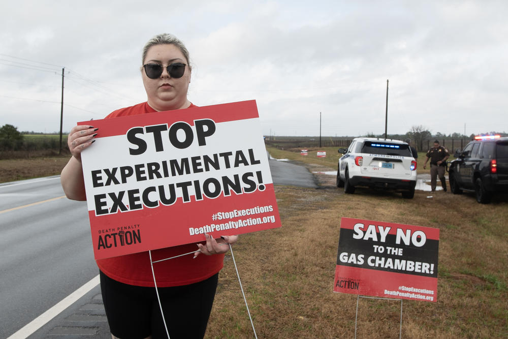 Alli Sullivan holds a sign protesting the use of nitrogen gas in executions on the road leading to Holman Correctional Facility in Atmore, Ala. She is on the communications team at Death Penalty Action, an organization that seeks to stop executions and end the death penalty.