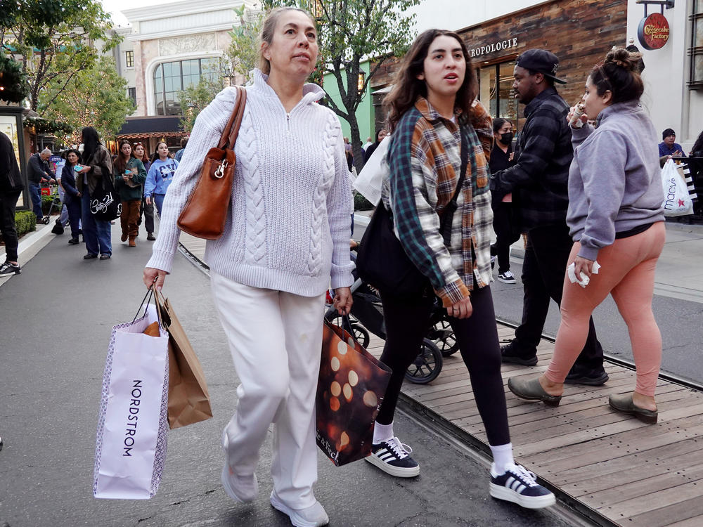 A person carries shopping bags at a shopping center on the day after Christmas on Dec. 26, 2023 in Glendale, Calif. Strong consumer spending helped drive better-than-expected economic growth in the final months of 2023.