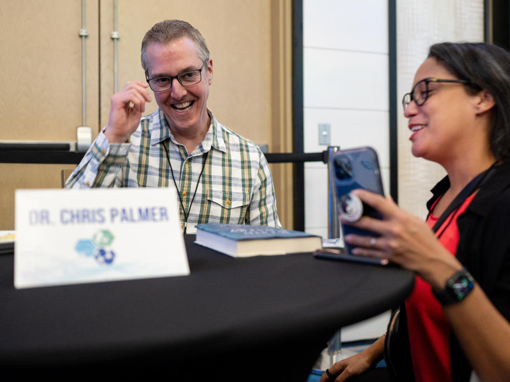 Dr. Chris Palmer (left) signs a copy of his book, <em>Brain Energy,</em> for Addanilka Ramos during the Metabolic Health Summit in Clearwater, Fla. Palmer has been researching the keto diet for years.
