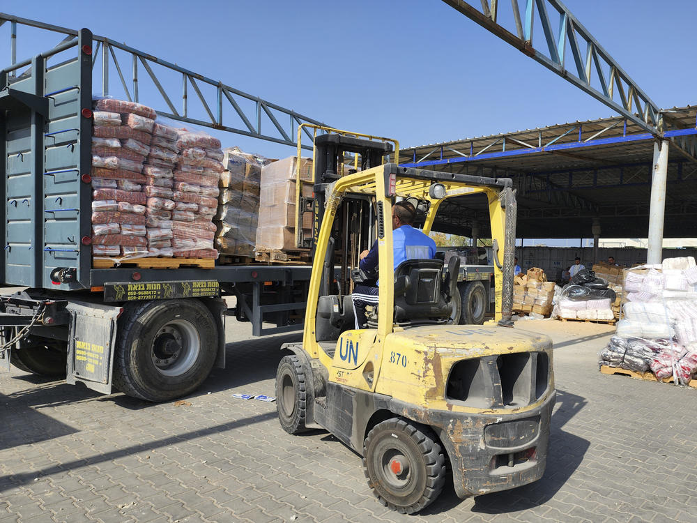 United Nations and Red Crescent workers prepare aid for distribution to Palestinians at a UNRWA warehouse in the Gaza Strip. The U.S. says 12 employees of UNRWA, which provides aid to Palestinians, were involved in Hamas' Oct. 7 attack on Israel.