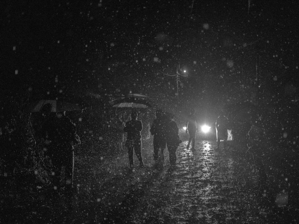 Dozens of people search in the rain for information about their captured relatives around Izalco jail in Sonsonate, a city west of San Salvador, in April 2022. Some people traveled for hours and slept in the street because they lived up to five hours away from the jail.