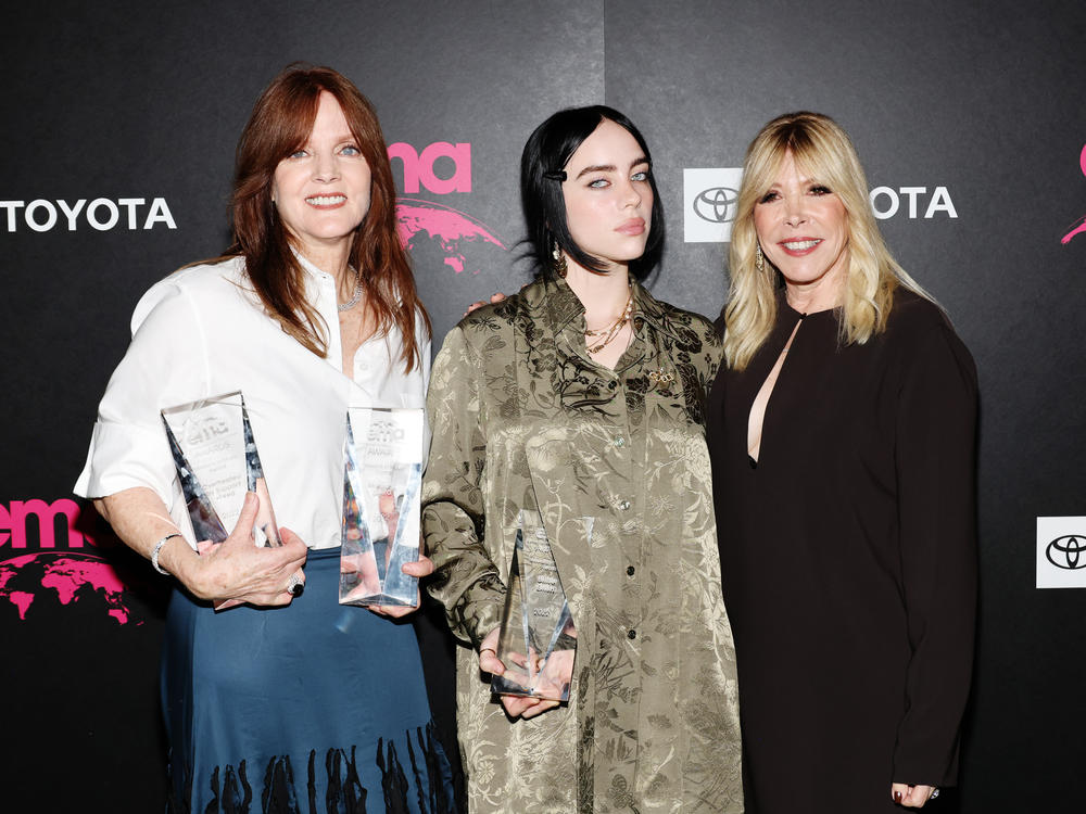 Billie Eilish at the 32nd Environmental Media Association (EMA) Awards Gala in Los Angeles, Oct. 8 2022. The pop star is flanked by her mother Maggie Baird (left) and EMA CEO Debbie Levin.