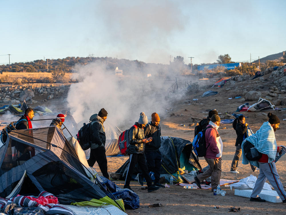 Migrants walk towards a Border Patrol agent in the town of Jacumba. Those crossing the border are often being instructed by cartels to turn themselves over to agents, in order to receive asylum.