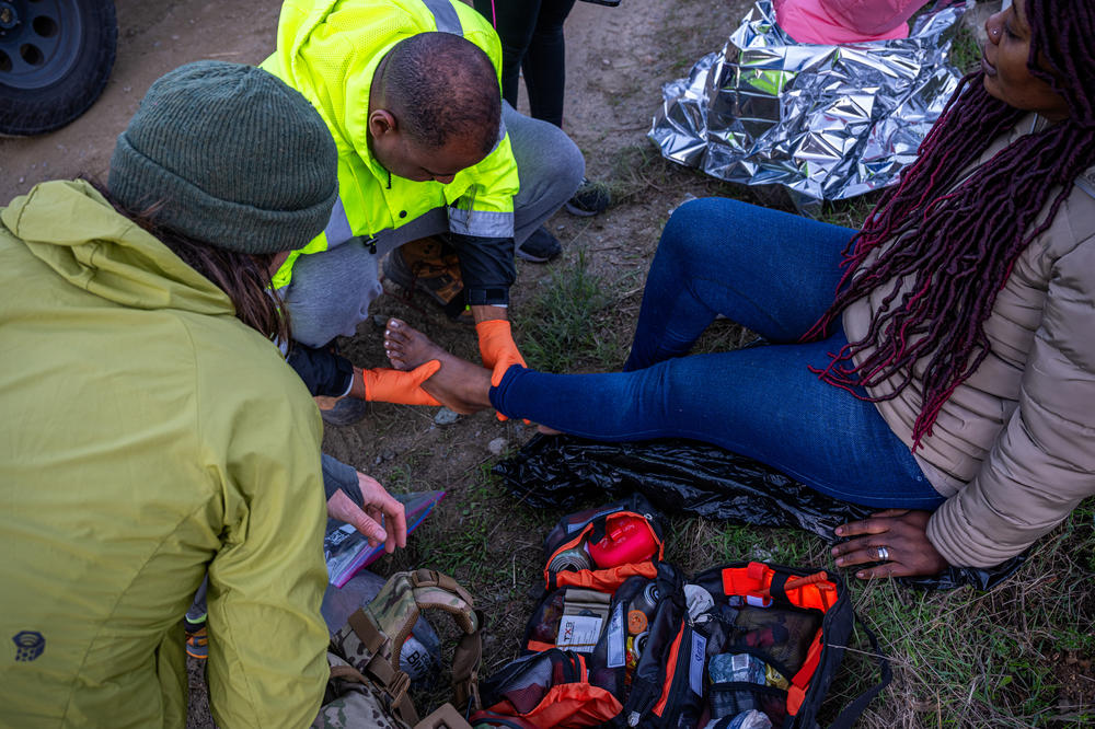 Members of the Borderlands Relief Collective attend to the wounds of a woman from Guinea with lacerations and blisters on her feet.